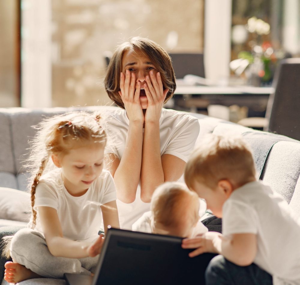 Coronavirus theme. Mother with children. Family stay at home. Kids watchs a cartoons.